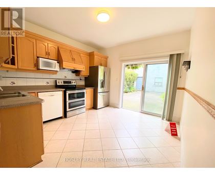 A kitchen with wooden cabinets and appliances.