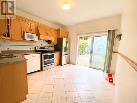 A kitchen with wooden cabinets and appliances.