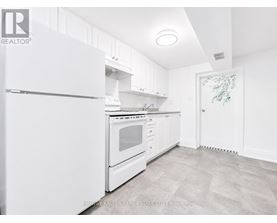 A white kitchen with a refrigerator, oven, and cabinets.