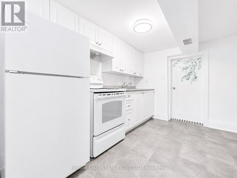 A white kitchen with a refrigerator, oven, and cabinets.