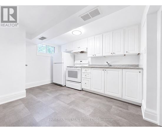 A kitchen with white cabinets and appliances in a real estate listing.