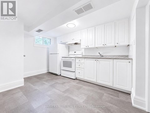 A kitchen with white cabinets and appliances in a real estate listing.