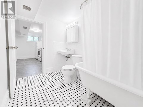 A white bathroom with a black and white floor.