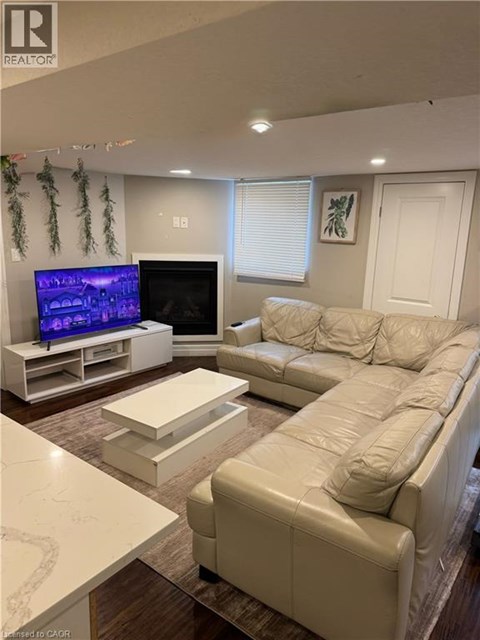 A living room with a white couch and a television.