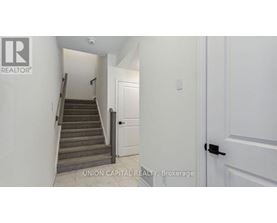 A hallway with a staircase leading to the second floor.