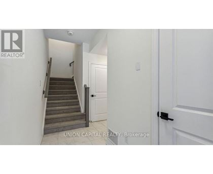 A hallway with a staircase leading to the second floor.