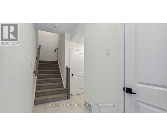 A hallway with a staircase leading to the second floor.