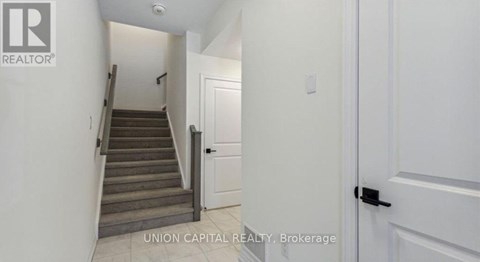 A hallway with a staircase leading to the second floor.