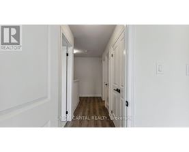 A hallway with white walls and wooden floors.
