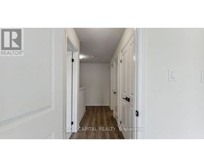 A hallway with white walls and wooden floors.