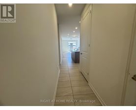 A hallway with a brokerage sign on the wall.