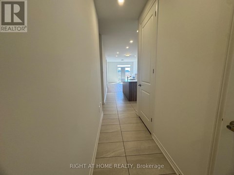 A hallway with a brokerage sign on the wall.