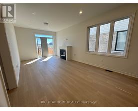A spacious room with wooden flooring and a large window.