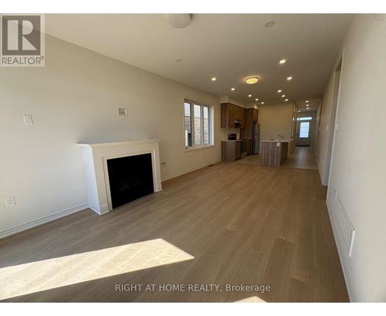 A spacious living room with a fireplace and wood flooring.