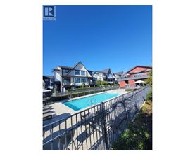 A pool surrounded by a fence and houses.