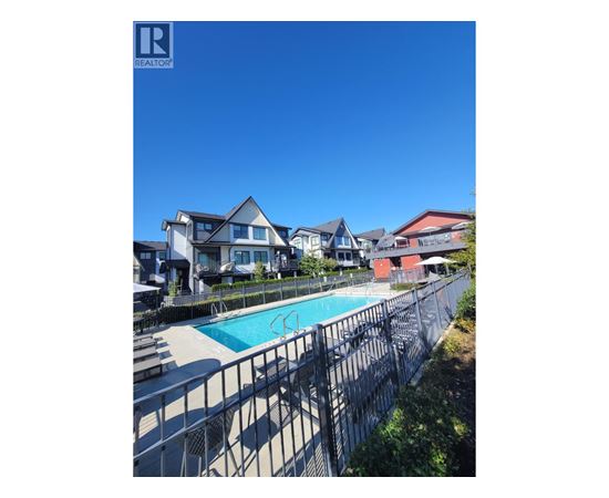 A pool surrounded by a fence and houses.