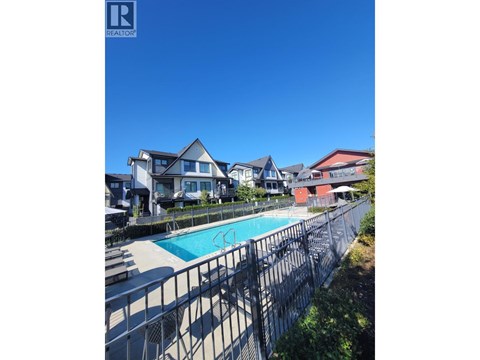 A pool surrounded by a fence and houses.