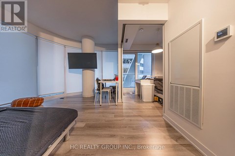 A modern bedroom with a large bed and a flat screen TV.