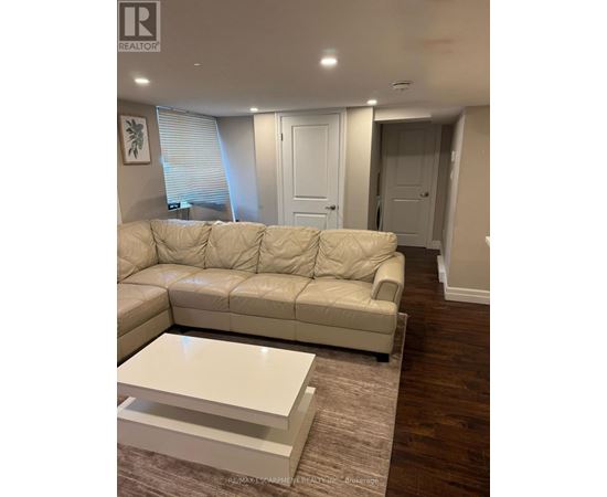 A living room with a white sofa and a coffee table.