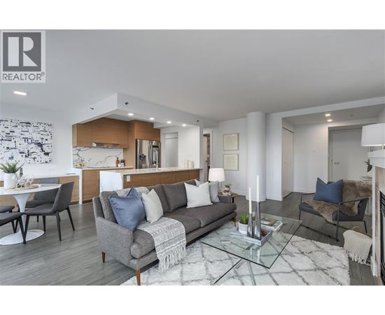 A modern living room with a grey sofa and a glass coffee table.
