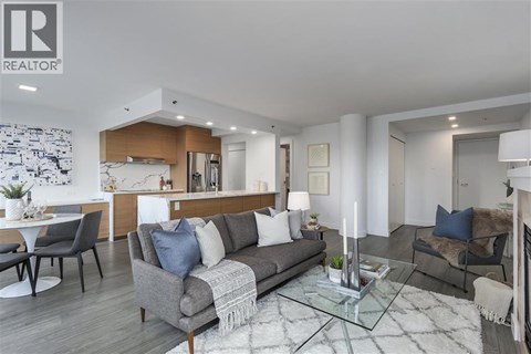 A modern living room with a grey sofa and a glass coffee table.