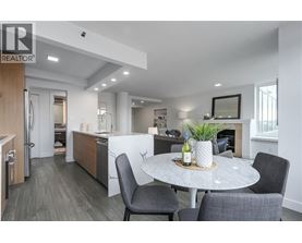 A modern kitchen with a dining table set for two.