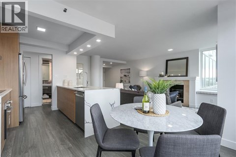 A modern kitchen with a dining table set for two.