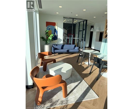 A modern living room with a blue sofa and orange chairs.