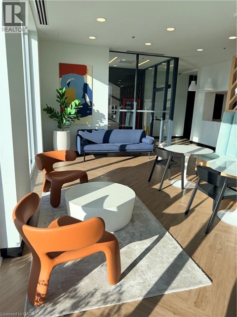 A modern living room with a blue sofa and orange chairs.