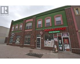 A brick building with a green roof and a sign that says Pizza Depot.
