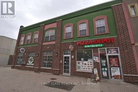 A brick building with a green roof and a sign that says Pizza Depot.