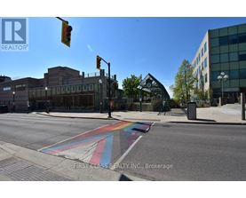 A street with a rainbow crosswalk in front of a library.
