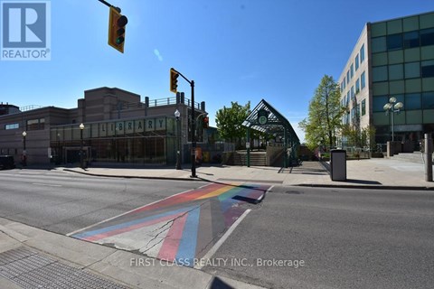 A street with a rainbow crosswalk in front of a library.