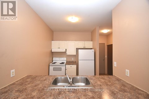 A kitchen with a sink and a refrigerator.