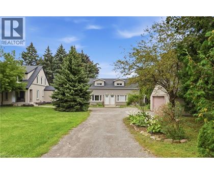 A house with a driveway and trees in front of it.