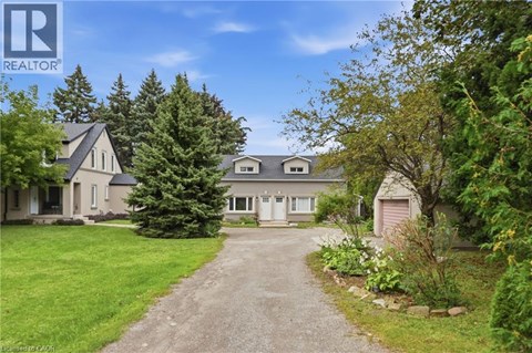 A house with a driveway and trees in front of it.