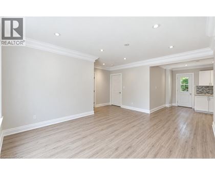 A spacious room with wooden flooring and white walls.