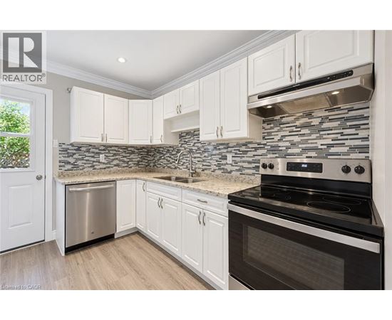 A kitchen with white cabinets and a black stove top oven.