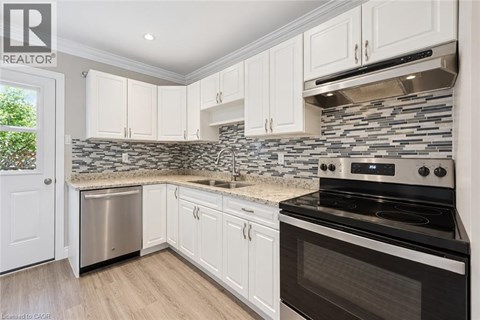 A kitchen with white cabinets and a black stove top oven.