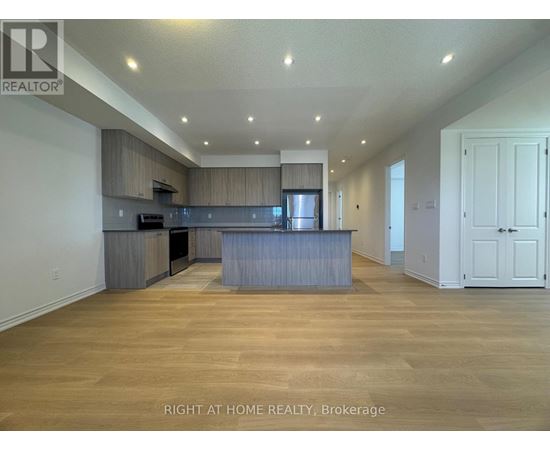 A spacious kitchen with wooden floors and a large island.