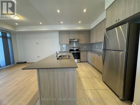 A modern kitchen with a stainless steel refrigerator and wooden cabinets.