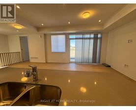 A spacious room with a sink and a window with blinds.