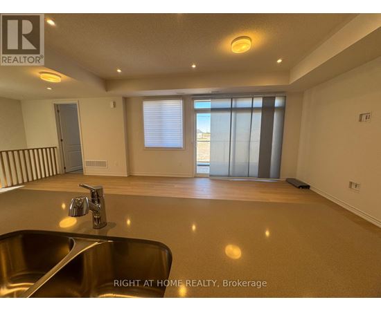 A spacious room with a sink and a window with blinds.