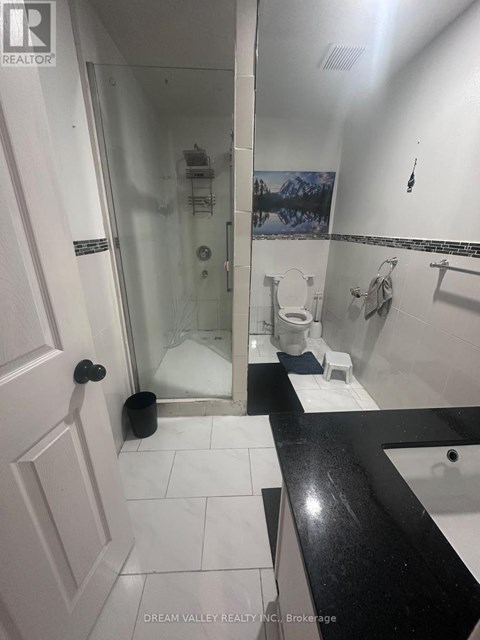 A bathroom with a toilet, sink, and shower.