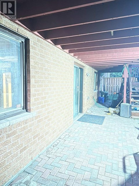 A patio with a brick wall and a tiled floor.