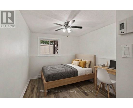 A bedroom with a bed, desk, and chair.