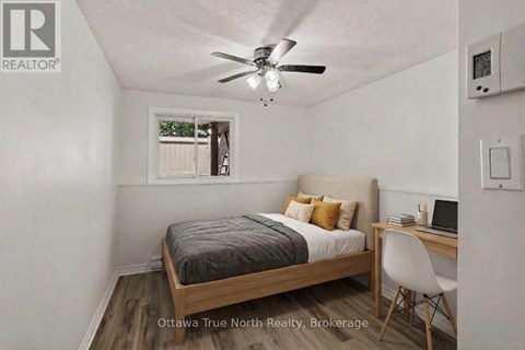 A bedroom with a bed, desk, and chair.