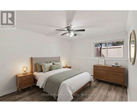 A bedroom with a bed, nightstands, and a ceiling fan.