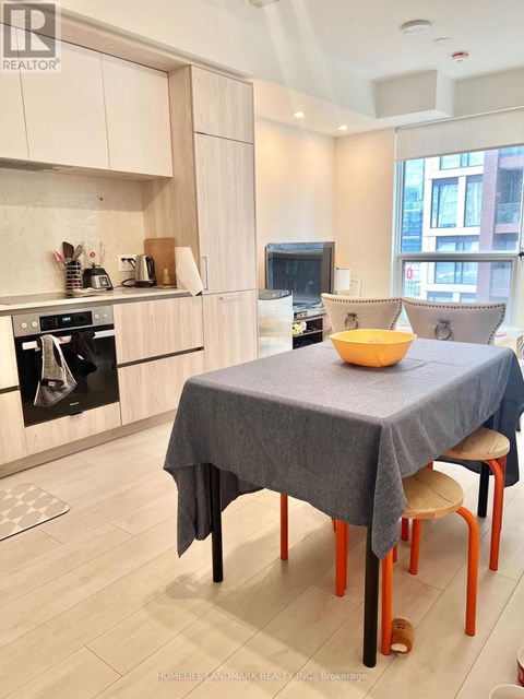 A kitchen with a table and chairs in front of it.