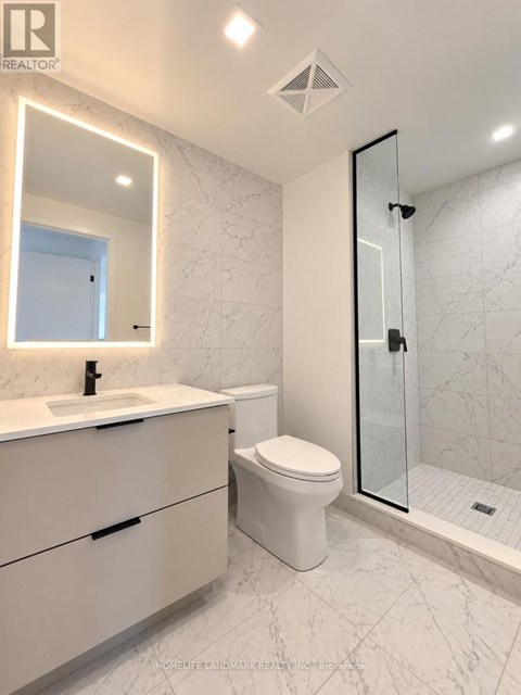 A white bathroom with a marble floor and a walk-in shower.